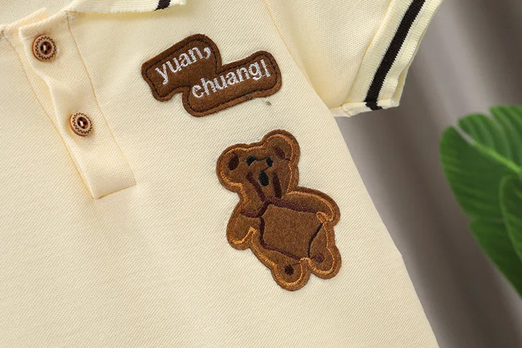 Beige baby polo shirt with brown teddy bear patch and embroidered text, short sleeves, cotton