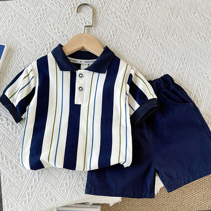 Baby boy summer outfit with navy striped polo shirt and solid navy shorts on a hanger