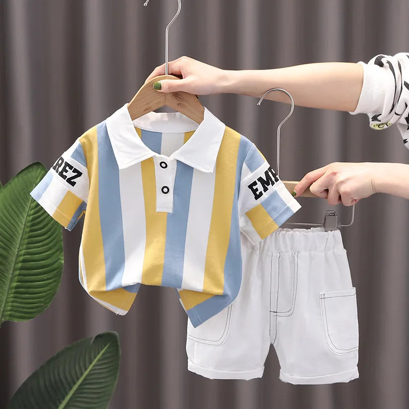 Baby summer outfit with striped yellow and blue short sleeve shirt and white shorts on hangers.