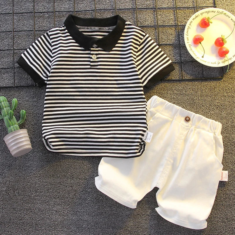 Striped baby boy polo shirt and white shorts set, summer infant outfit flat lay.