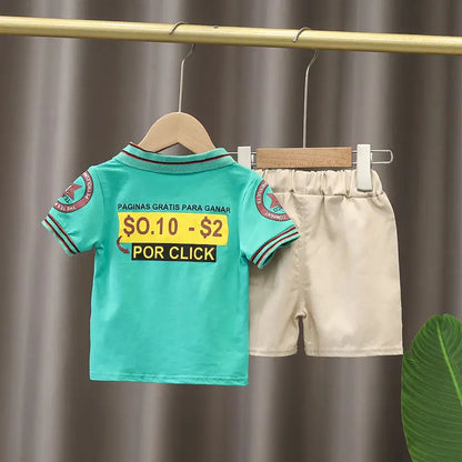 Kids summer outfit with green graphic t-shirt and beige shorts hanging on rack